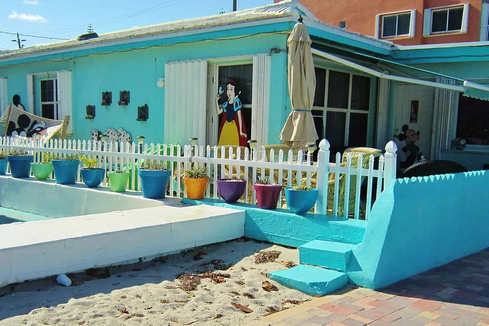 A turquoise beach cottage with a picket fence on the Hollywood Beach Broadwalk, Florida